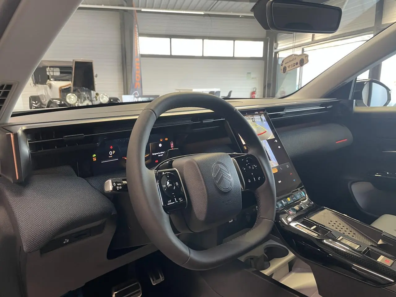 Intérieur du Citroën C5 Aircross 2026 vu côté conducteur, volant noir et écran tactile vertical central.