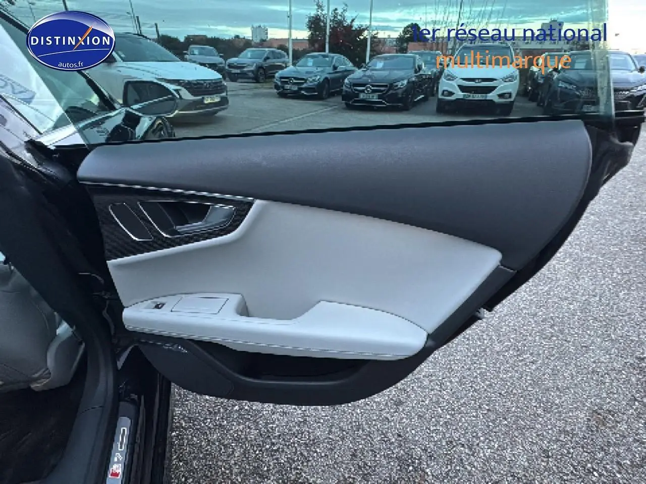 Vue intérieure de la porte avant gauche noire de l'Audi S7 Sportback avec garniture claire et insert carbone.