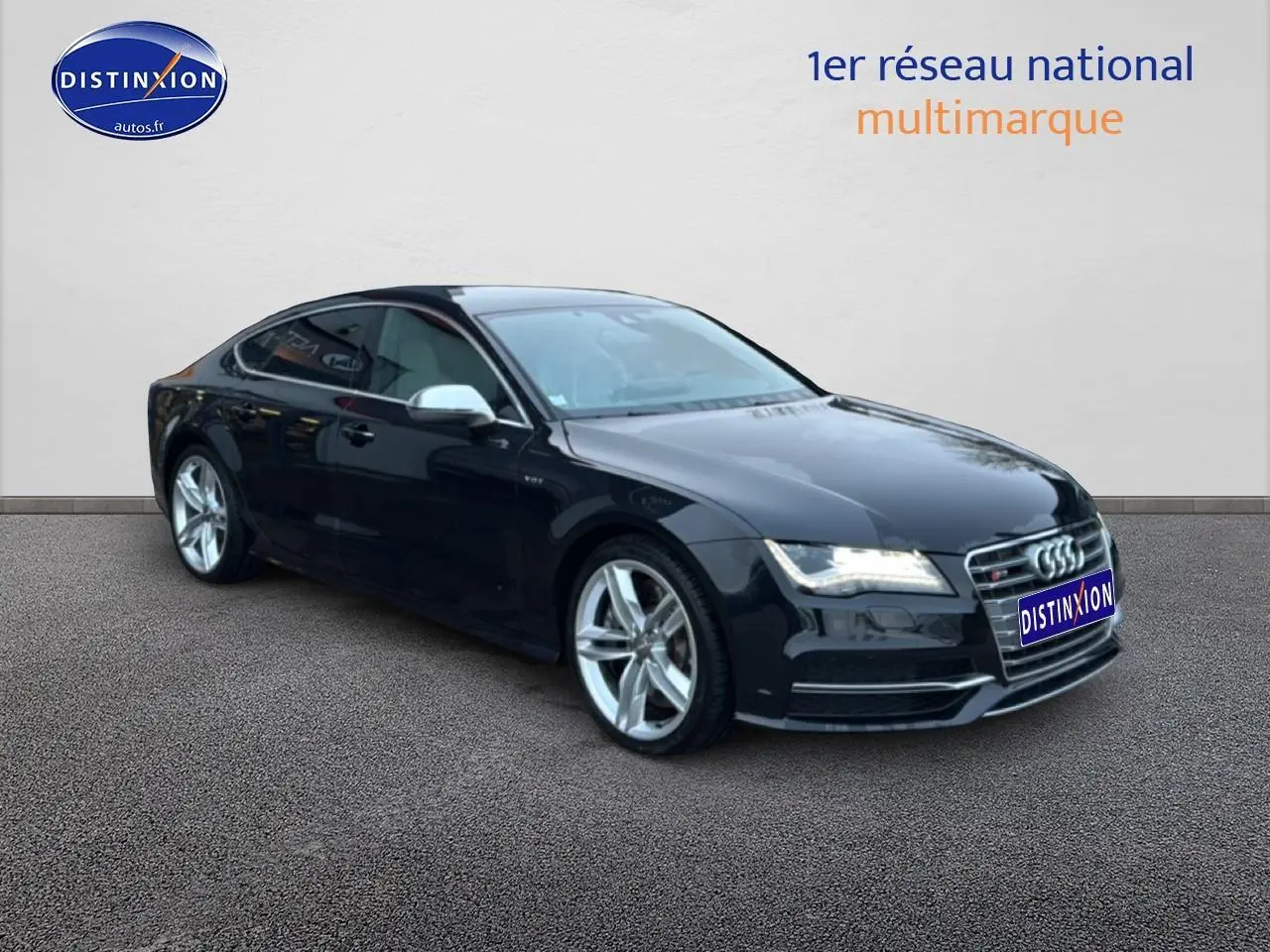 Audi S7 Sportback noir vue 3/4 avant droit, jantes alu et calandre chromée brillante sur fond neutre.