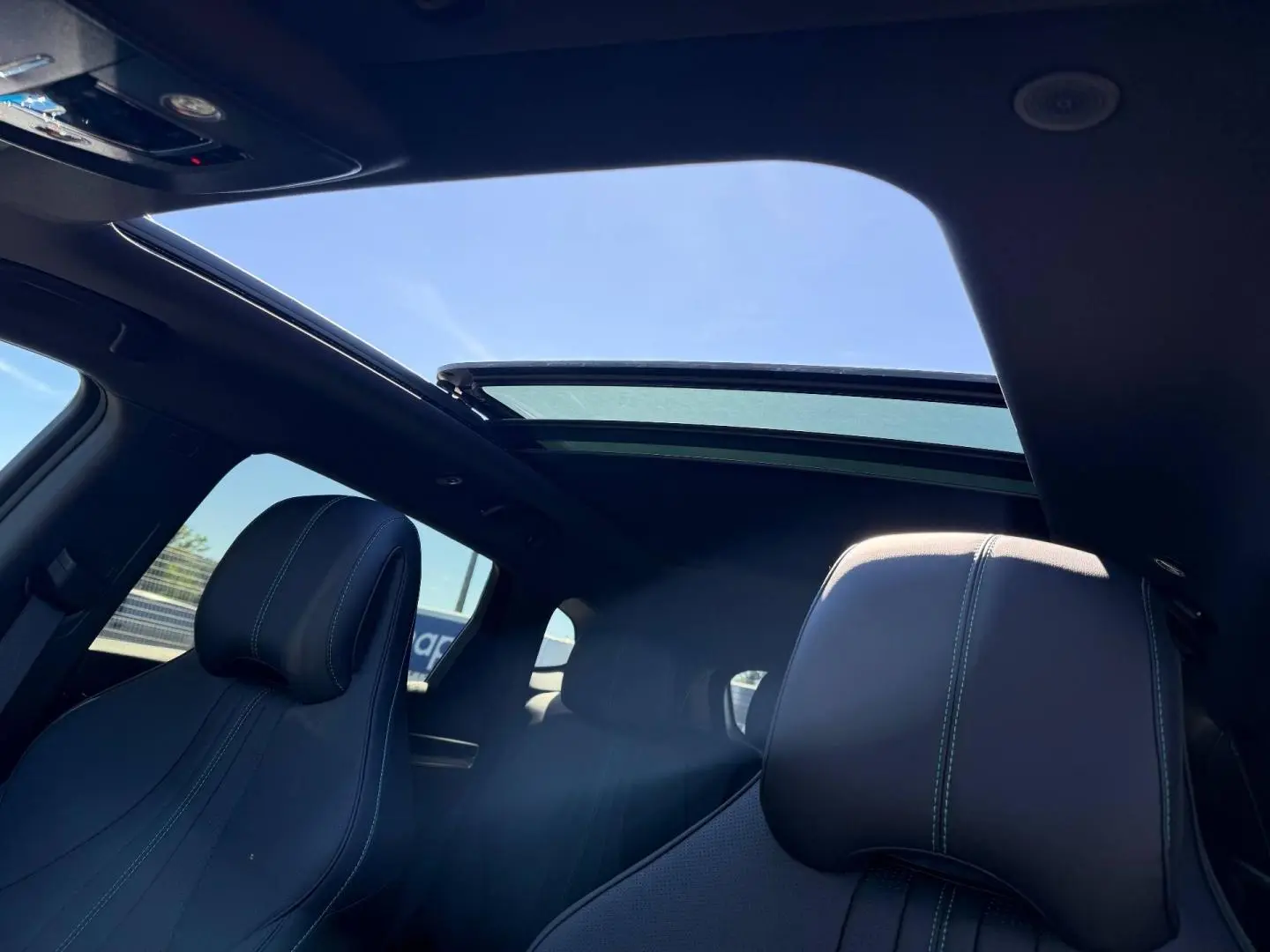 Vue intérieure du toit panoramique ouvert et des sièges avant en cuir noir du BYD SEAL U 1.5 DM-i 324ch Design AWD.