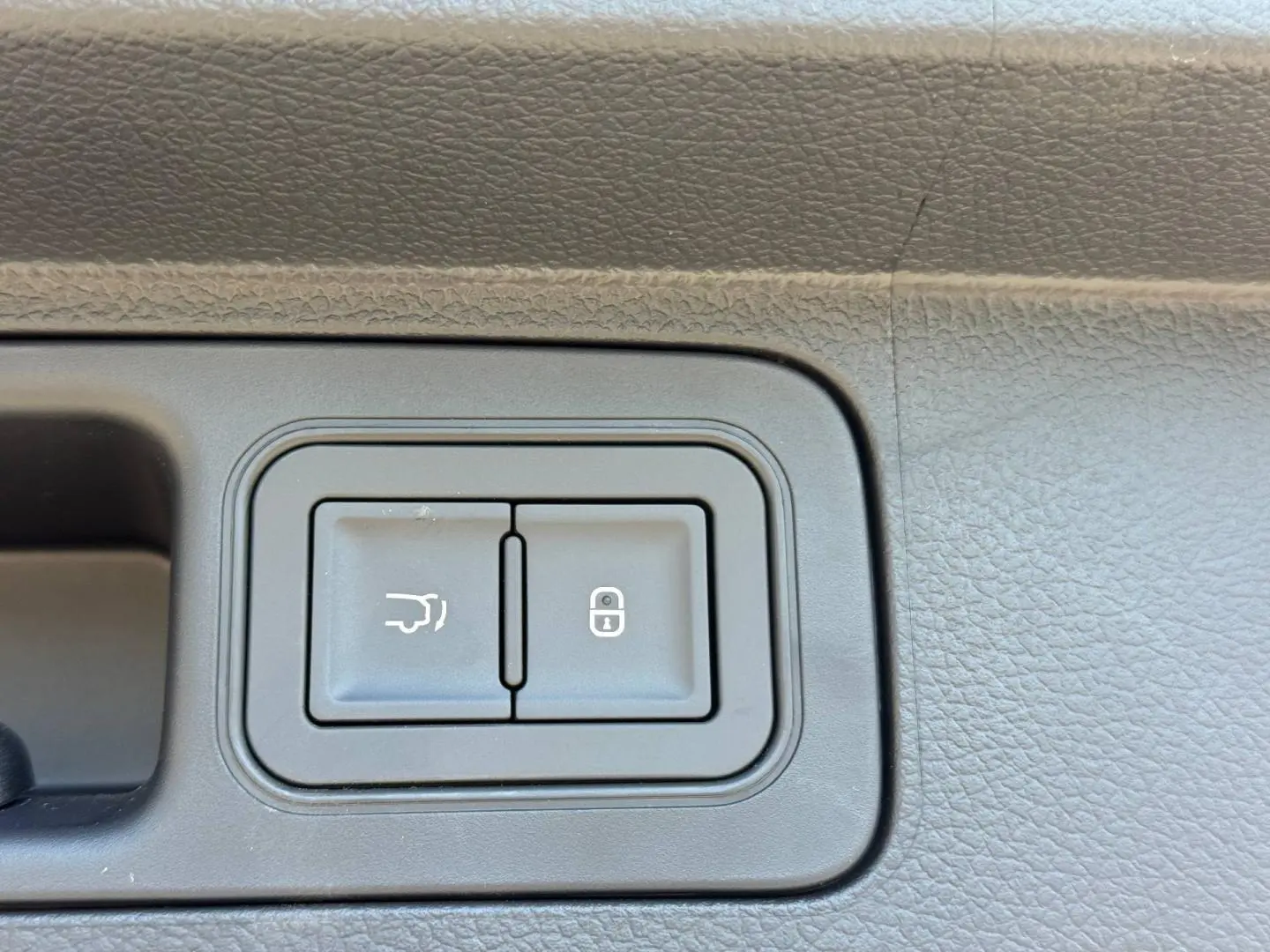 Gros plan sur les boutons d'ouverture du coffre et de verrouillage sur la portière intérieure noire du BYD SEAL U.