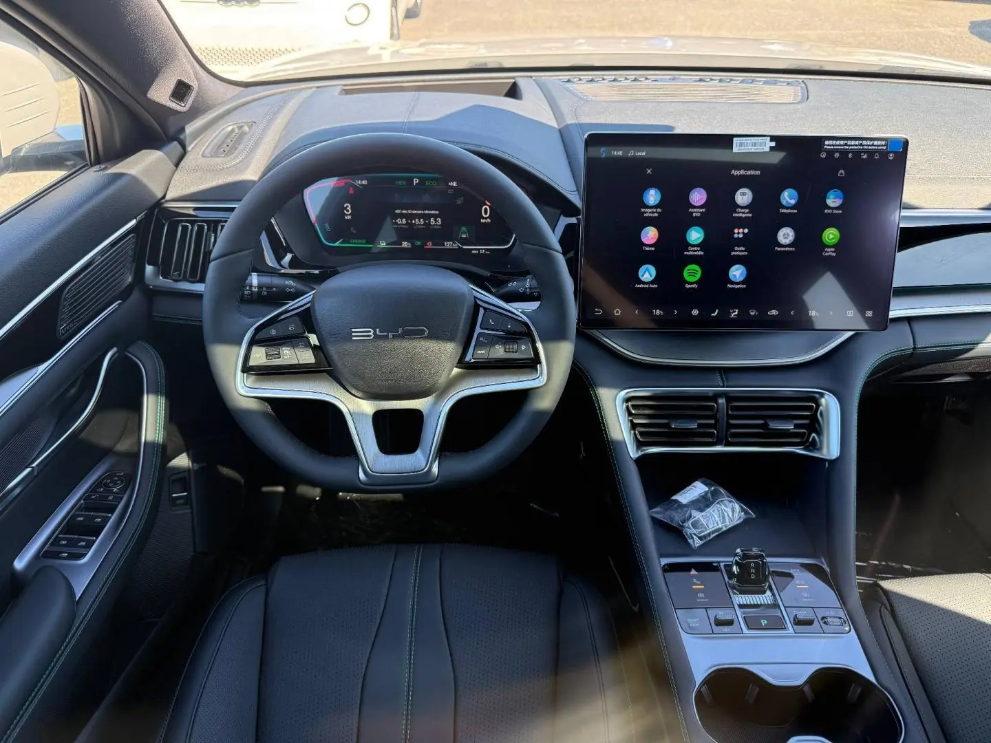 Vue intérieure frontale du poste de conduite BYD SEAL U 2026 avec volant multifonction, écran tactile large et console centrale épurée.