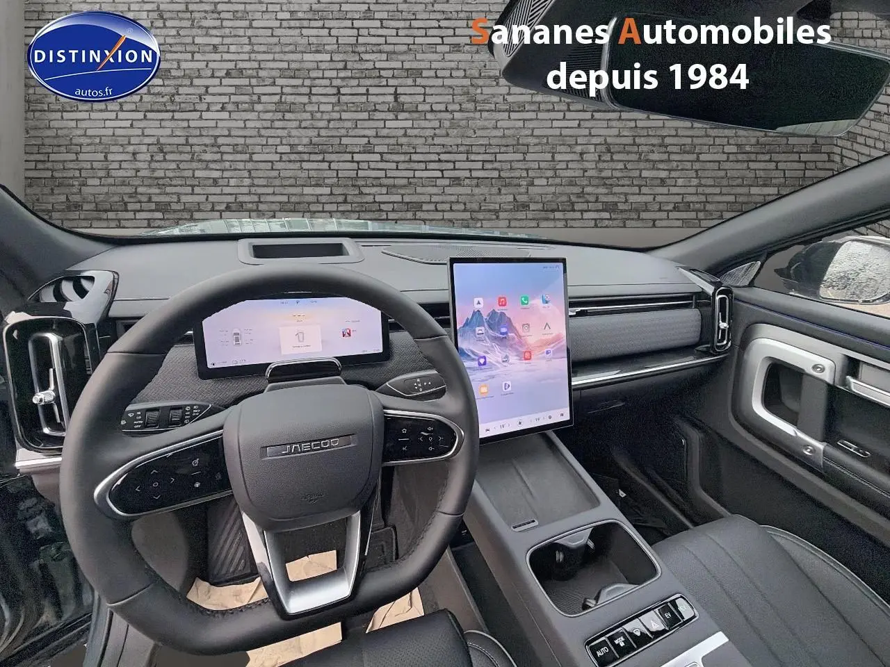 Vue intérieure du tableau de bord et volant du JAECOO J7 1.5 PHEV vert olive, avec écran tactile vertical central.