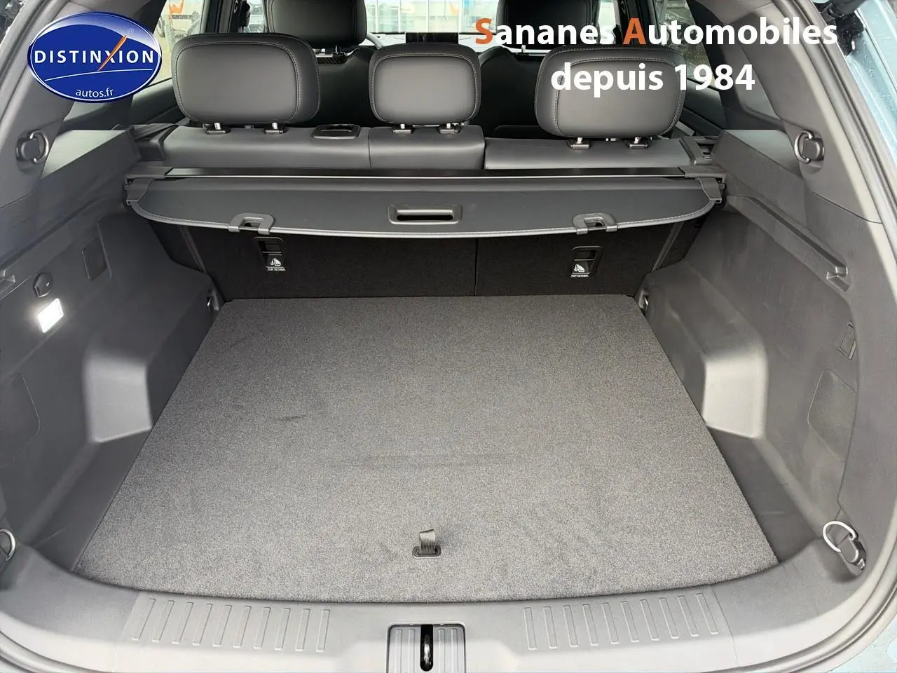 Coffre ouvert vu de l'arrière d'un JAECOO J7 1.5 PHEV Exclusive 2026, intérieur gris sans chargement visible.