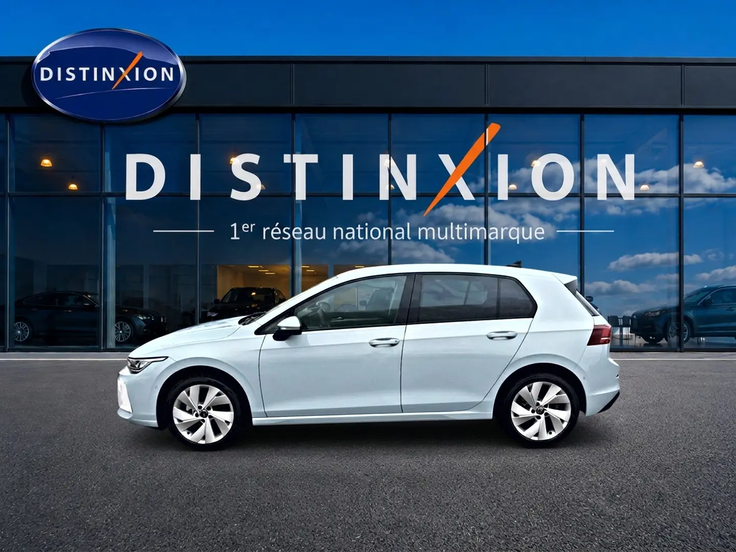 Vue latérale droite d'une Volkswagen Golf 1.5 ETSI evo2 116 Life DSG7 bleu glacier devant une vitrine Distinxion.