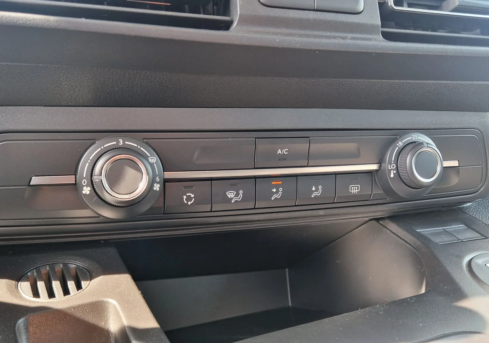 Gros plan sur la console centrale du Citroën Berlingo 2025 gris Artense, montrant les commandes manuelles de climatisation.