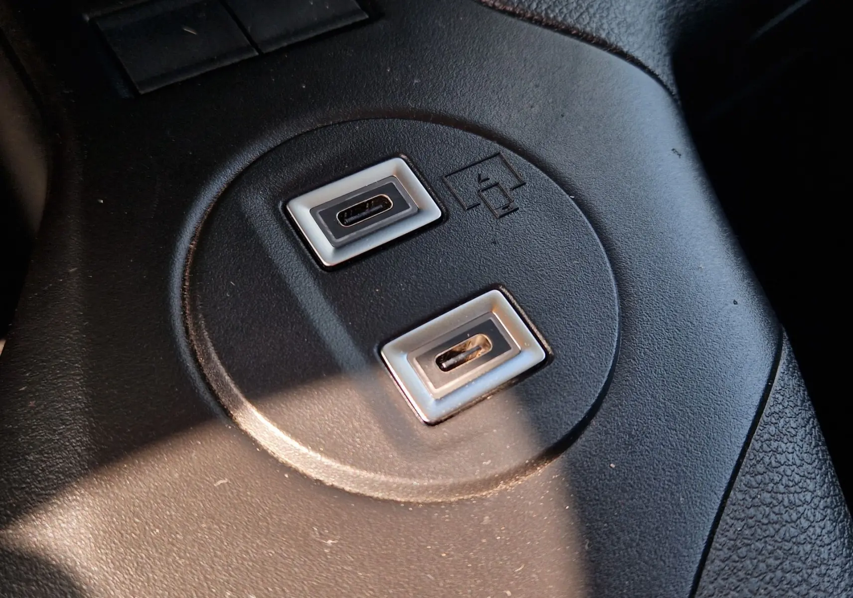 Gros plan sur les ports USB-C doubles intégrés dans la console centrale noire du Citroën Berlingo gris Artense.