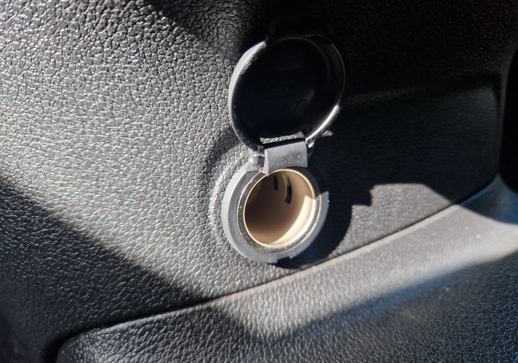 Prise 12V ouverte sur le tableau de bord noir texturé du Citroën Berlingo M 1.5 BlueHDi 2025.