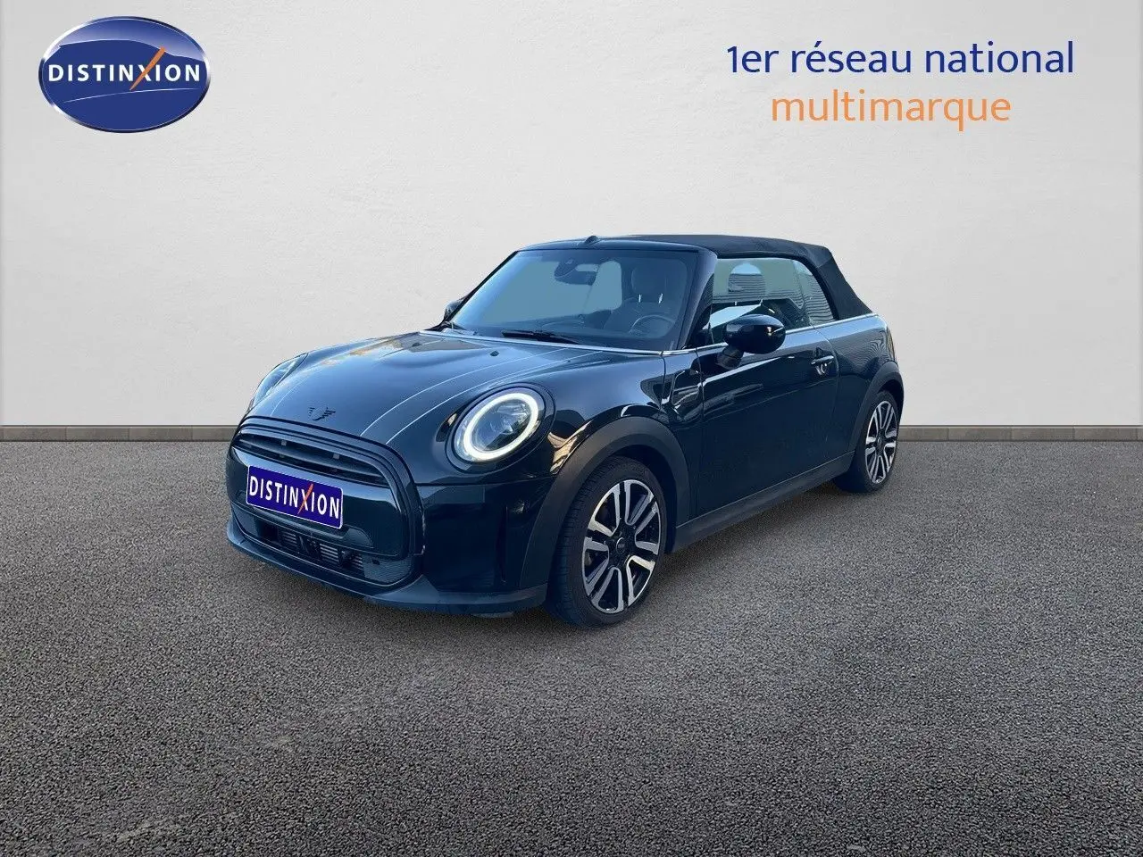 Vue 3/4 avant d'une MINI Cabriolet F57 noire Midnight Metal avec capote fermée et jantes bi-ton.