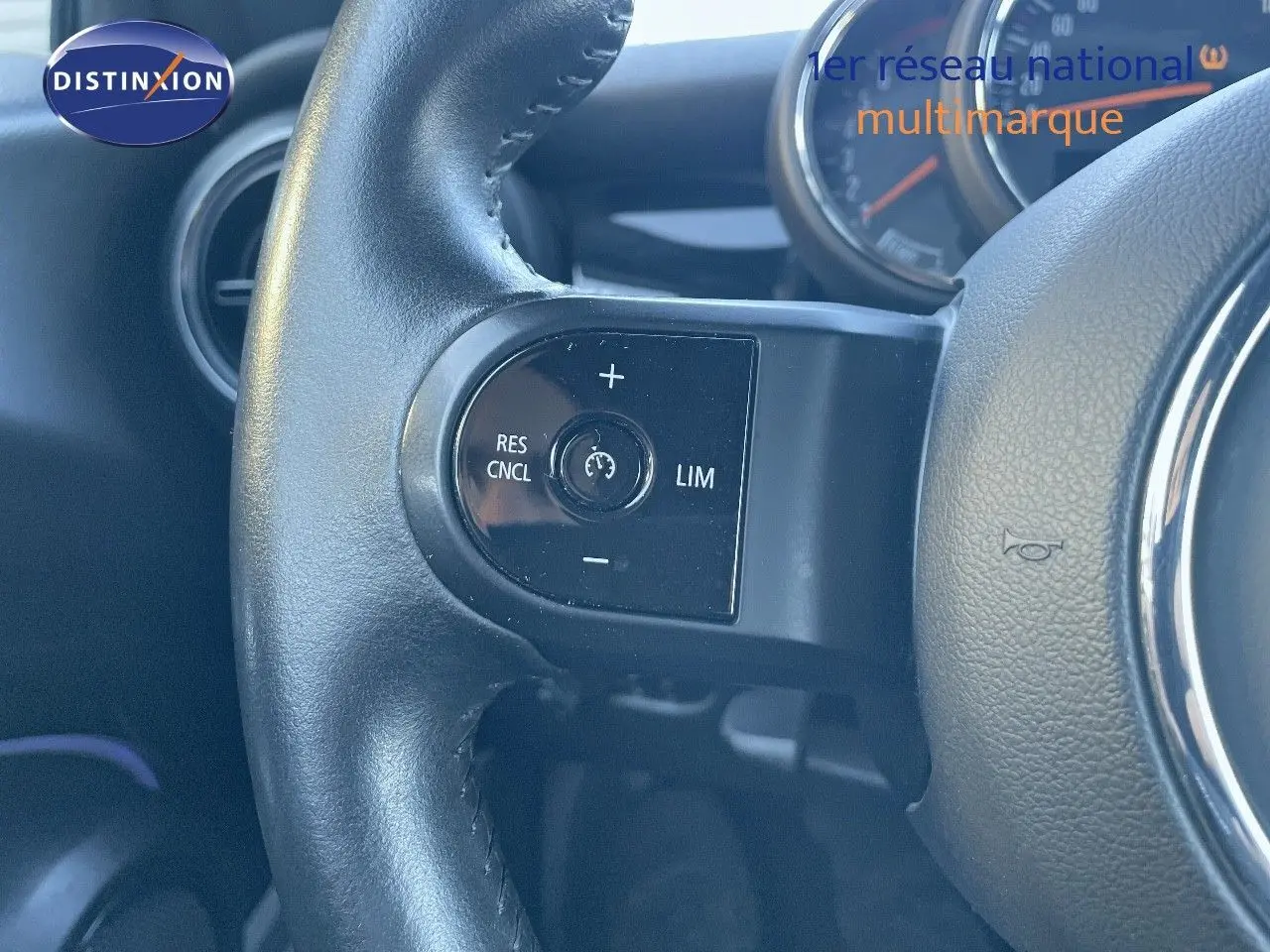 Gros plan sur le volant en cuir noir du MINI Cabriolet F57 2023, mettant en valeur les commandes de régulateur de vitesse.