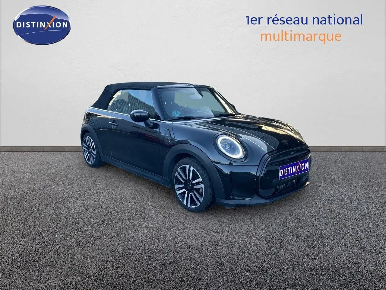 Vue 3/4 avant droite d'une MINI Cabriolet F57 noire Midnight Metal avec capote fermée et jantes bi-ton.