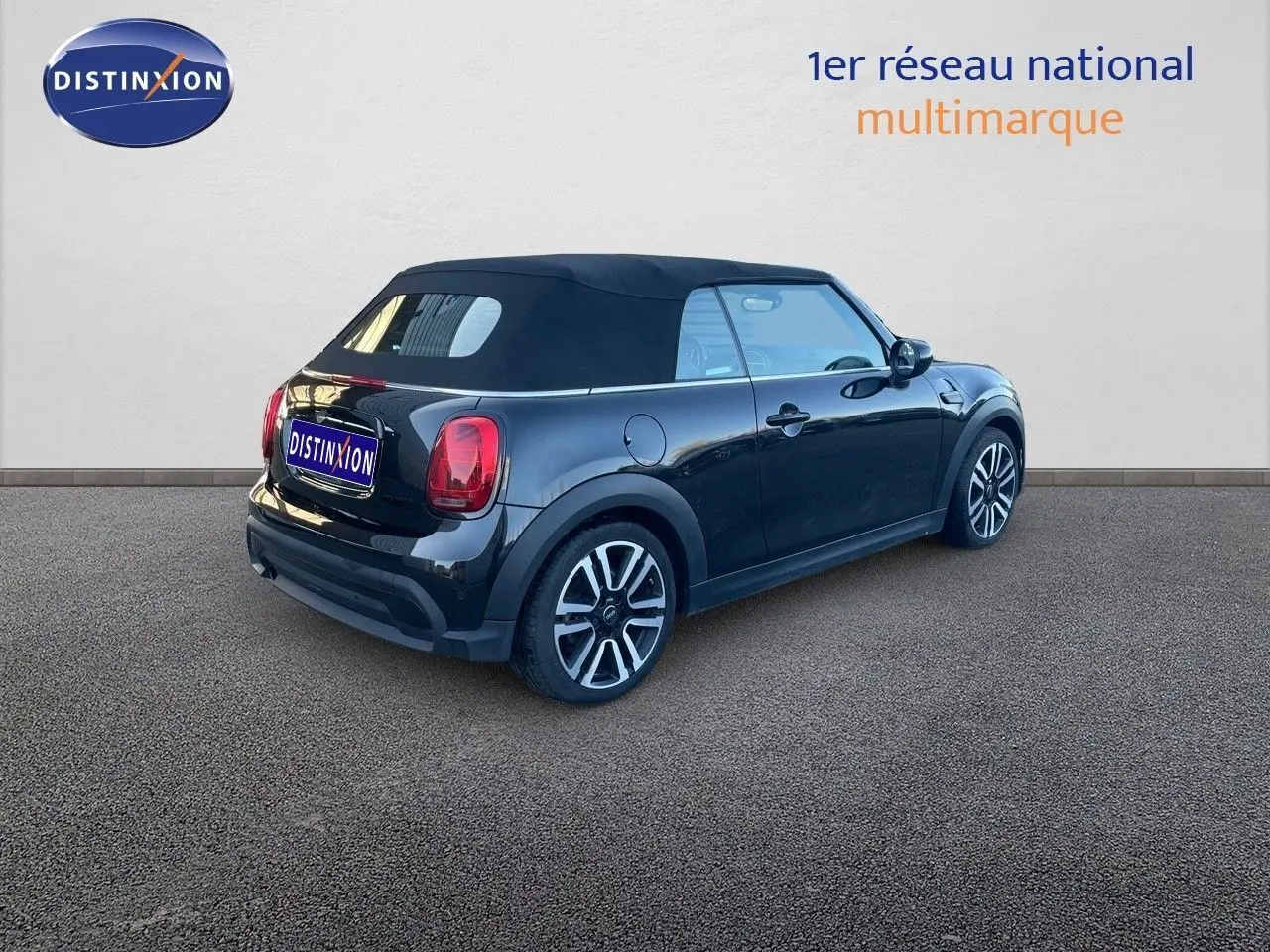 MINI Cabriolet F57 noir Midnight Metal vue 3/4 arrière droit avec capote noire fermée sur sol goudronné.