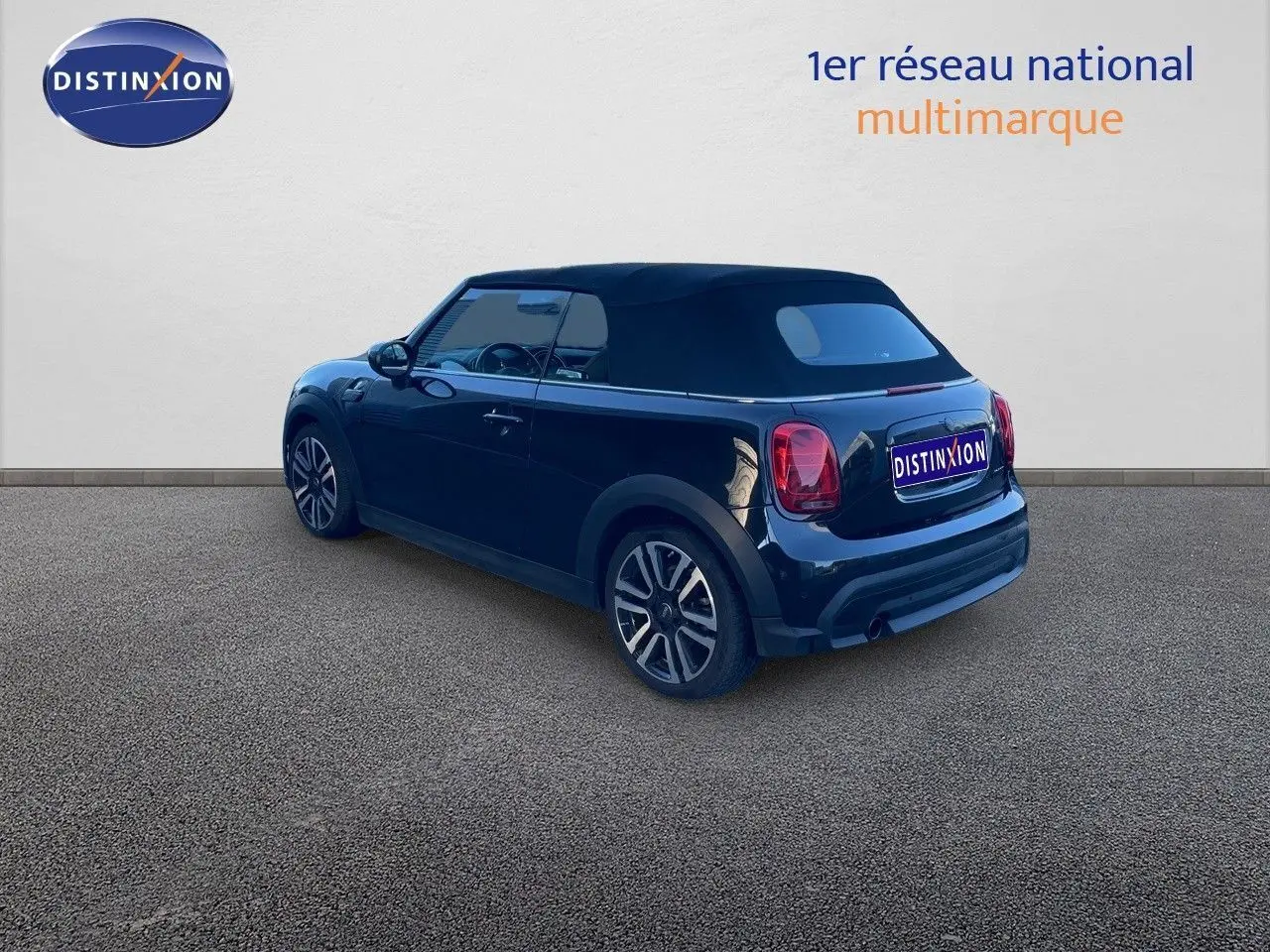 Vue 3/4 arrière droite d'une MINI Cabriolet F57 noire Midnight Metal avec toit fermé sur fond neutre.