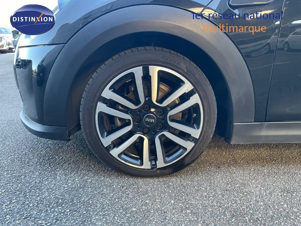Gros plan sur la roue avant gauche d'une MINI Cabriolet F57 noire Midnight Metal avec jante alu bi-ton 17 pouces.