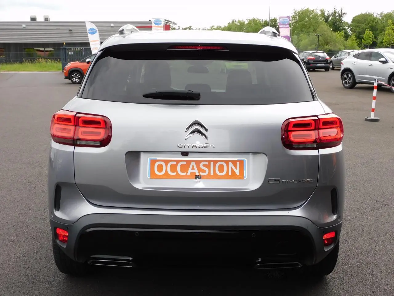 Vue arrière d'un Citroën C5 Aircross gris avec feux arrière LED et plaque d'immatriculation "OCCASION" visible.