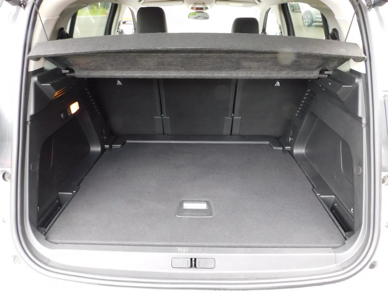 Coffre ouvert vu de l'arrière du Citroën C5 Aircross 1.2 PureTech 130 Shine, intérieur noir spacieux et propre.