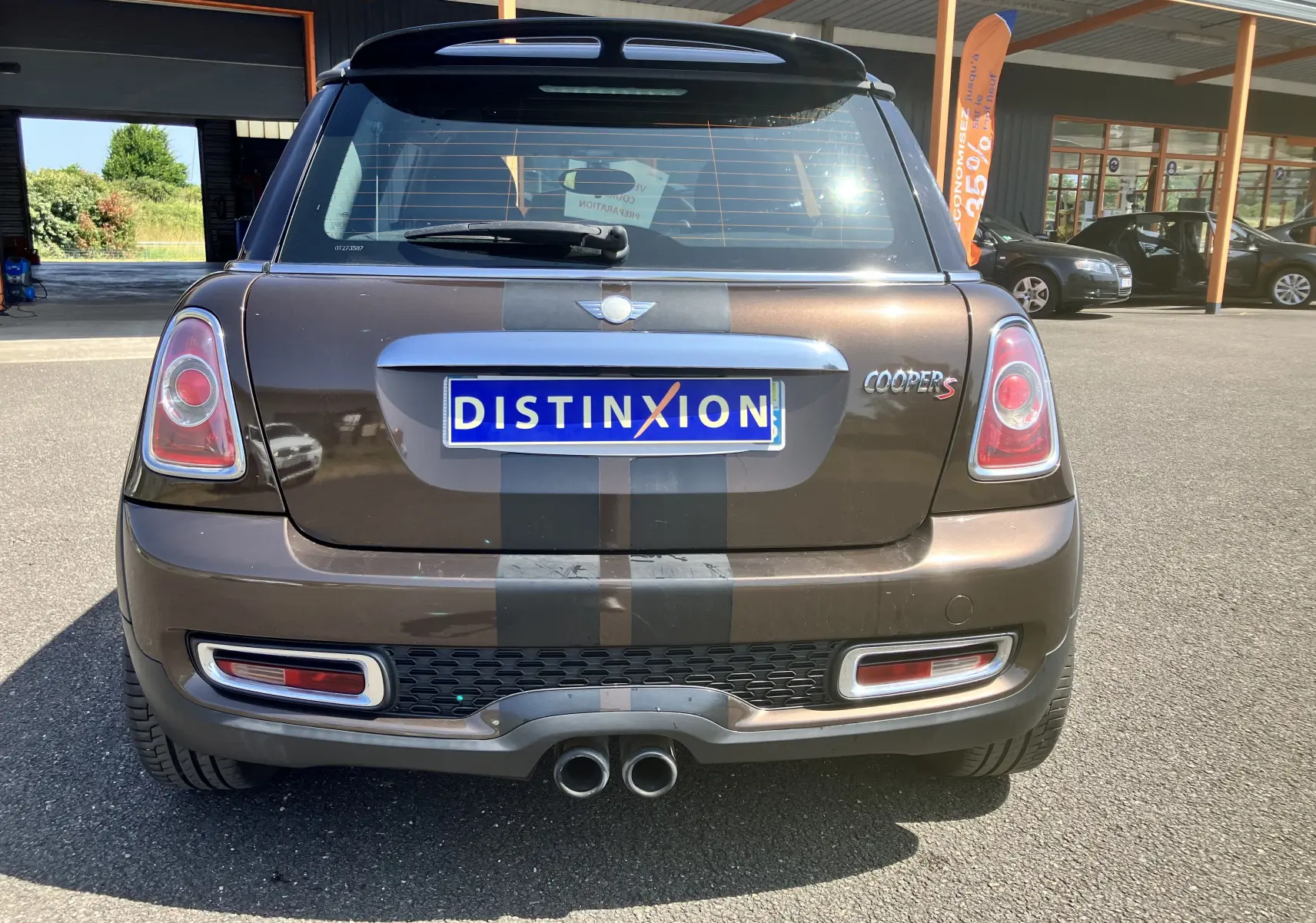 Vue arrière d'une MINI Cooper S R56 marron avec bandes noires et double sortie d'échappement centrale.