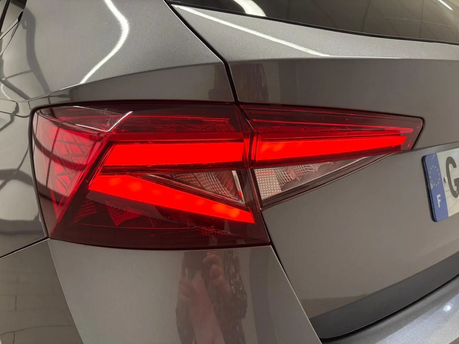 Gros plan sur le feu arrière droit allumé d'une Skoda Fabia 2023 gris graphite métallisé.