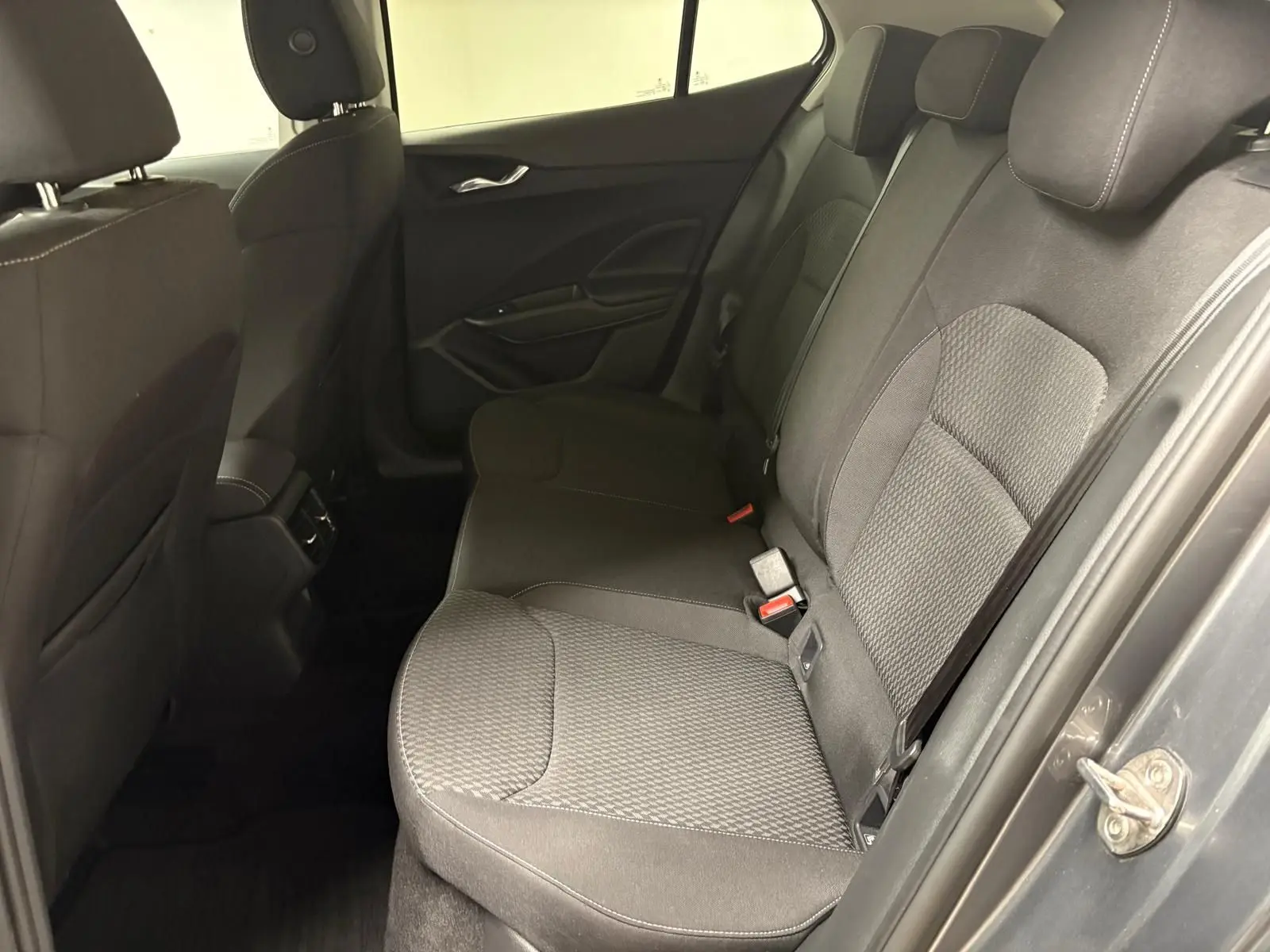 Vue intérieure côté droit des sièges arrière en tissu gris d'une Skoda Fabia 2023 finition Style avec porte ouverte.