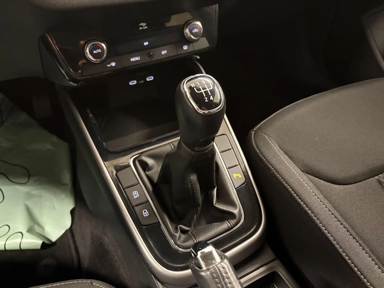 Gros plan sur la commande de la boîte manuelle et la console centrale de la Skoda Fabia 2023, intérieur noir.
