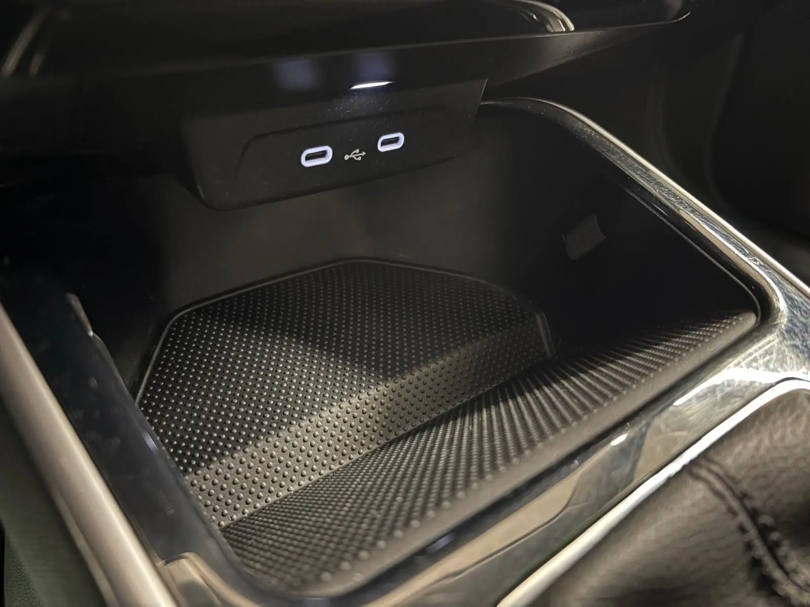 Gros plan sur la console centrale de la Skoda Fabia 2023, avec prise USB double et surface antidérapante noire.