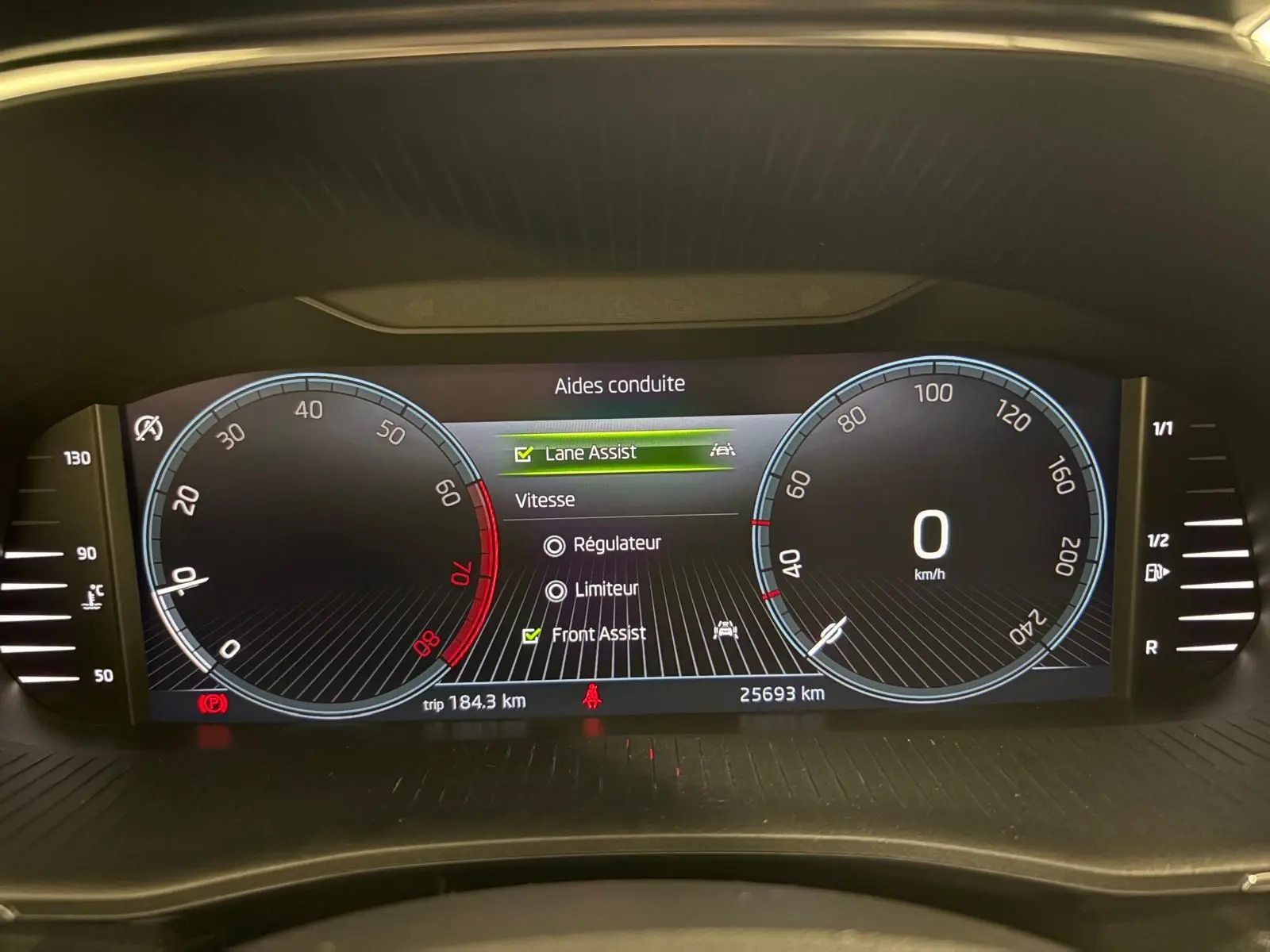 Tableau de bord numérique de la Skoda Fabia 2023 affichant les aides à la conduite et la vitesse à 0 km/h.