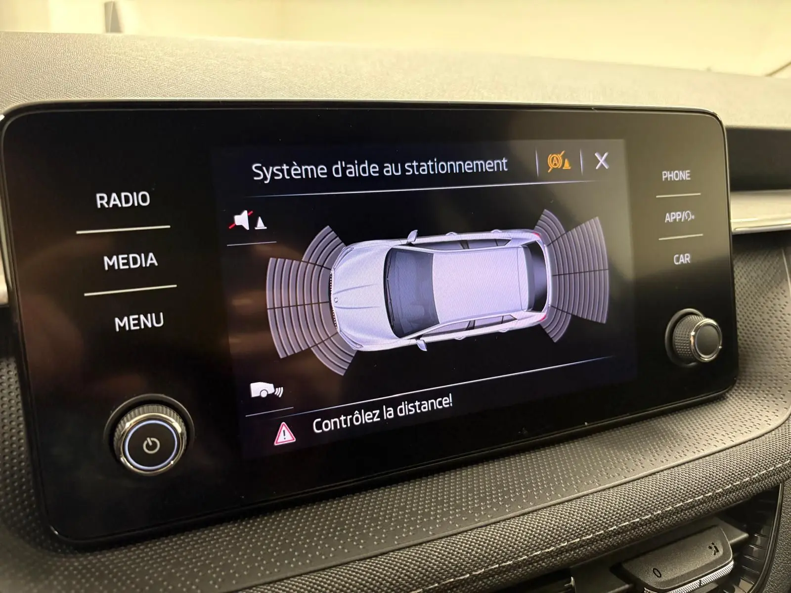 Écran du système d'aide au stationnement de la Skoda Fabia 2023, affichant une vue aérienne du véhicule gris graphite.