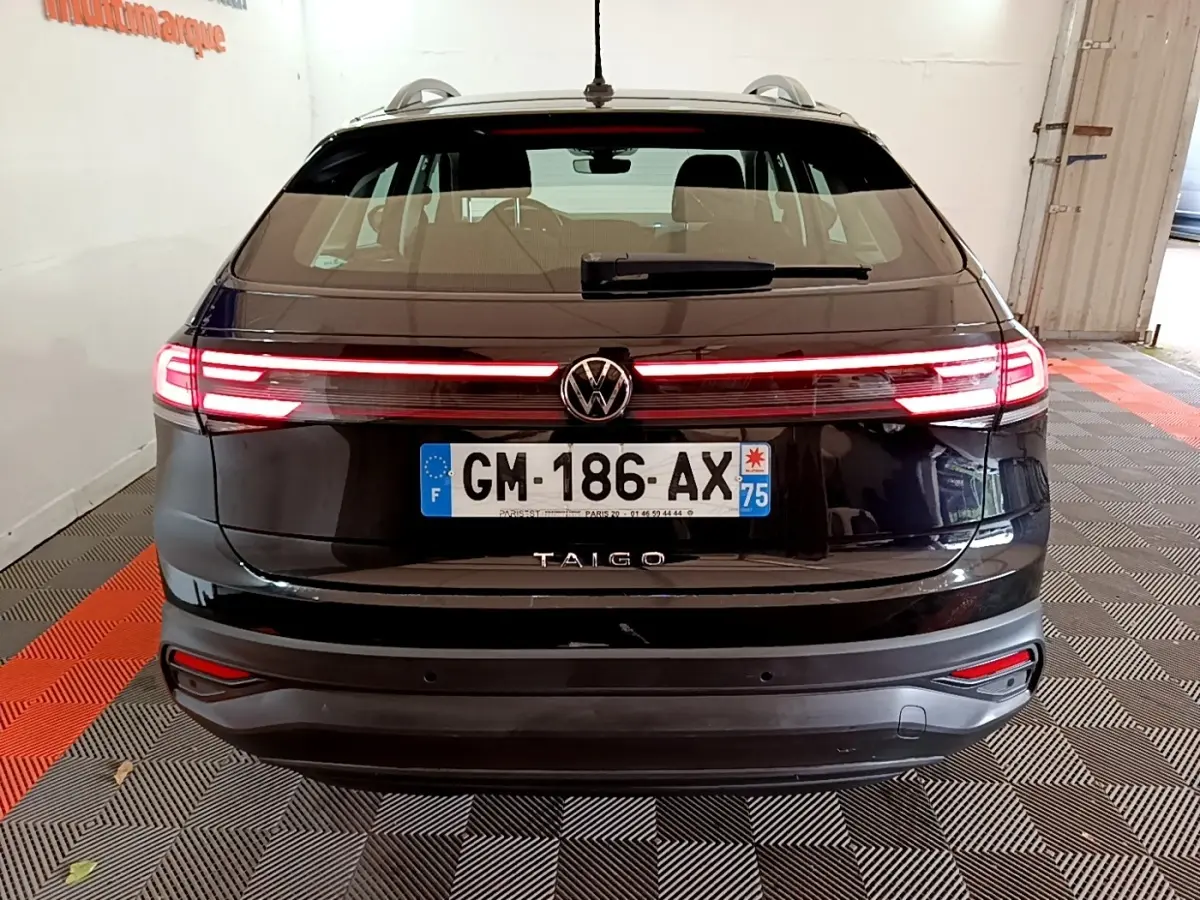 Vue arrière d’un Volkswagen Taigo noir 2023 avec feux LED allumés et plaque d’immatriculation française visible.