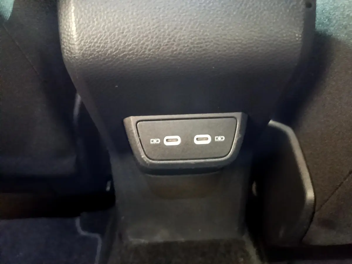 Prise USB double type C arrière sous l'accoudoir central d'un Volkswagen Taigo noir, version 2023.
