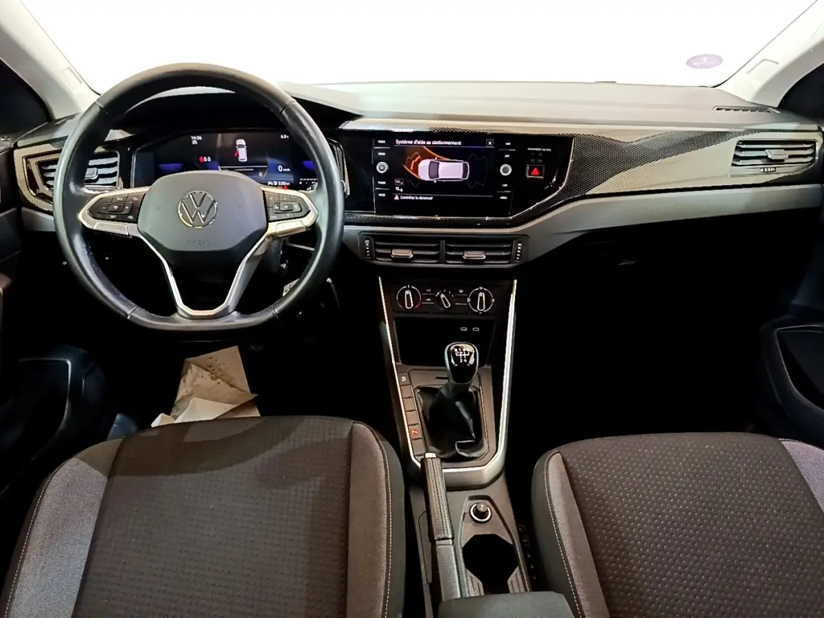 Vue intérieure avant du Volkswagen Taigo 1.0 TSI 95 Life 2023, volant cuir alu, boîte manuelle, tableau de bord digital.