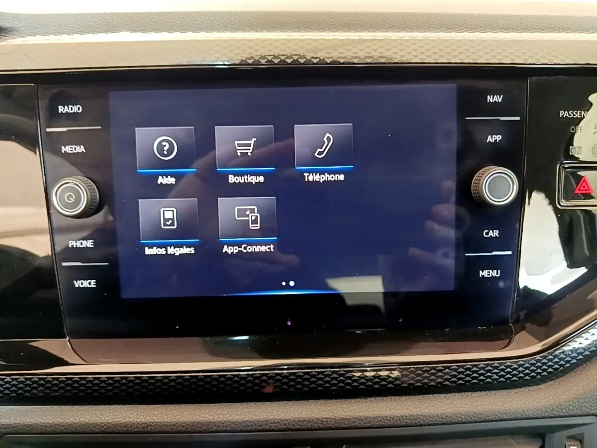 Vue rapprochée de l'écran tactile central du tableau de bord du Volkswagen Taigo noir, affichant les options multimédia.