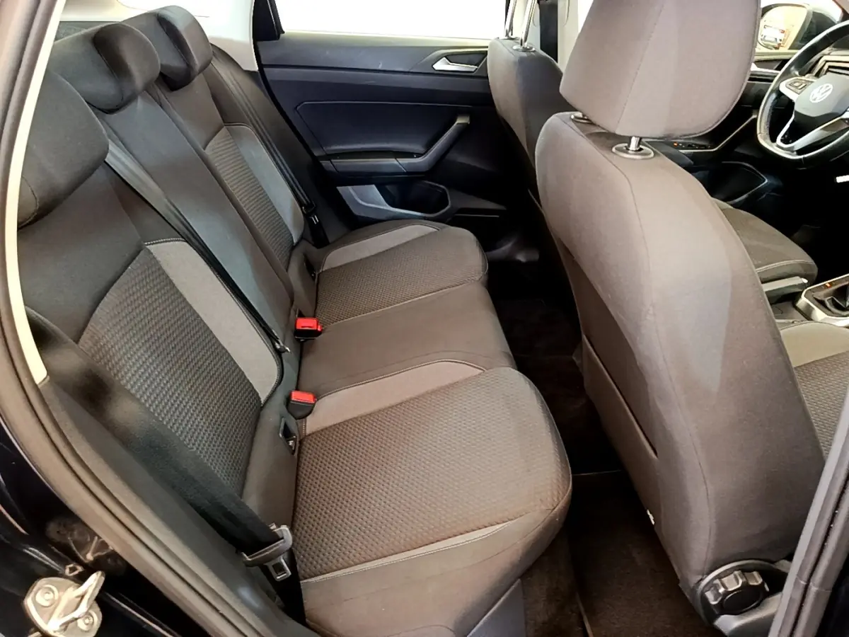 Vue intérieure côté arrière droit du Volkswagen Taigo noir 2023, montrant la banquette arrière et partie avant.