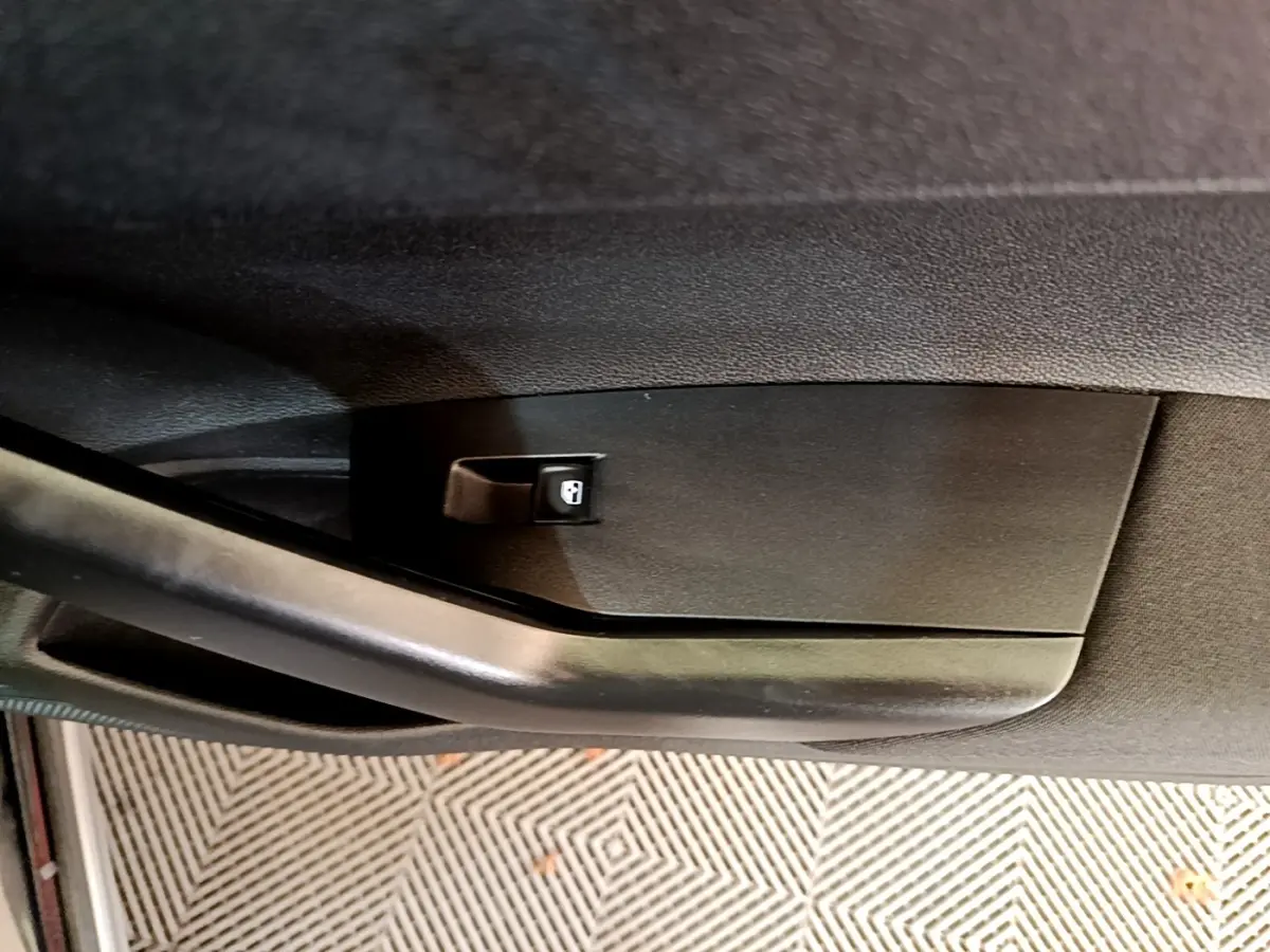 Gros plan sur la poignée intérieure noire de la porte côté conducteur du Volkswagen Taigo 1.0 TSI 95 Life 2023.