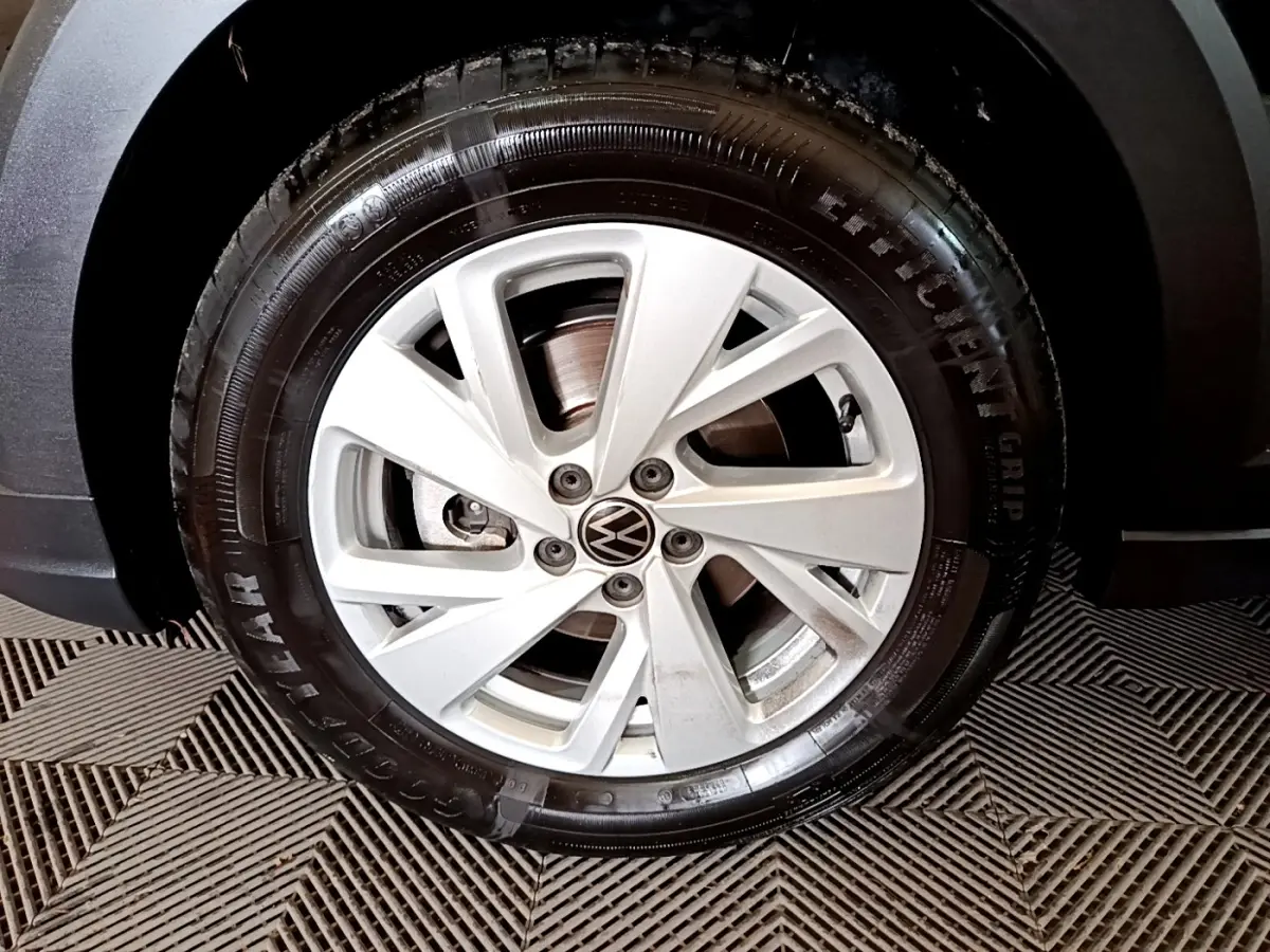 Gros plan sur la roue avant droite avec jante argentée et pneu Goodyear d’un Volkswagen Taigo noir.