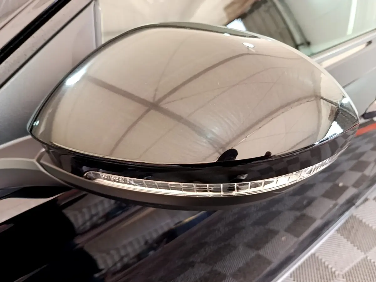 Gros plan sur le rétroviseur noir avec clignotant intégré du Volkswagen Taigo 1.0 TSI 95 Life côté conducteur.