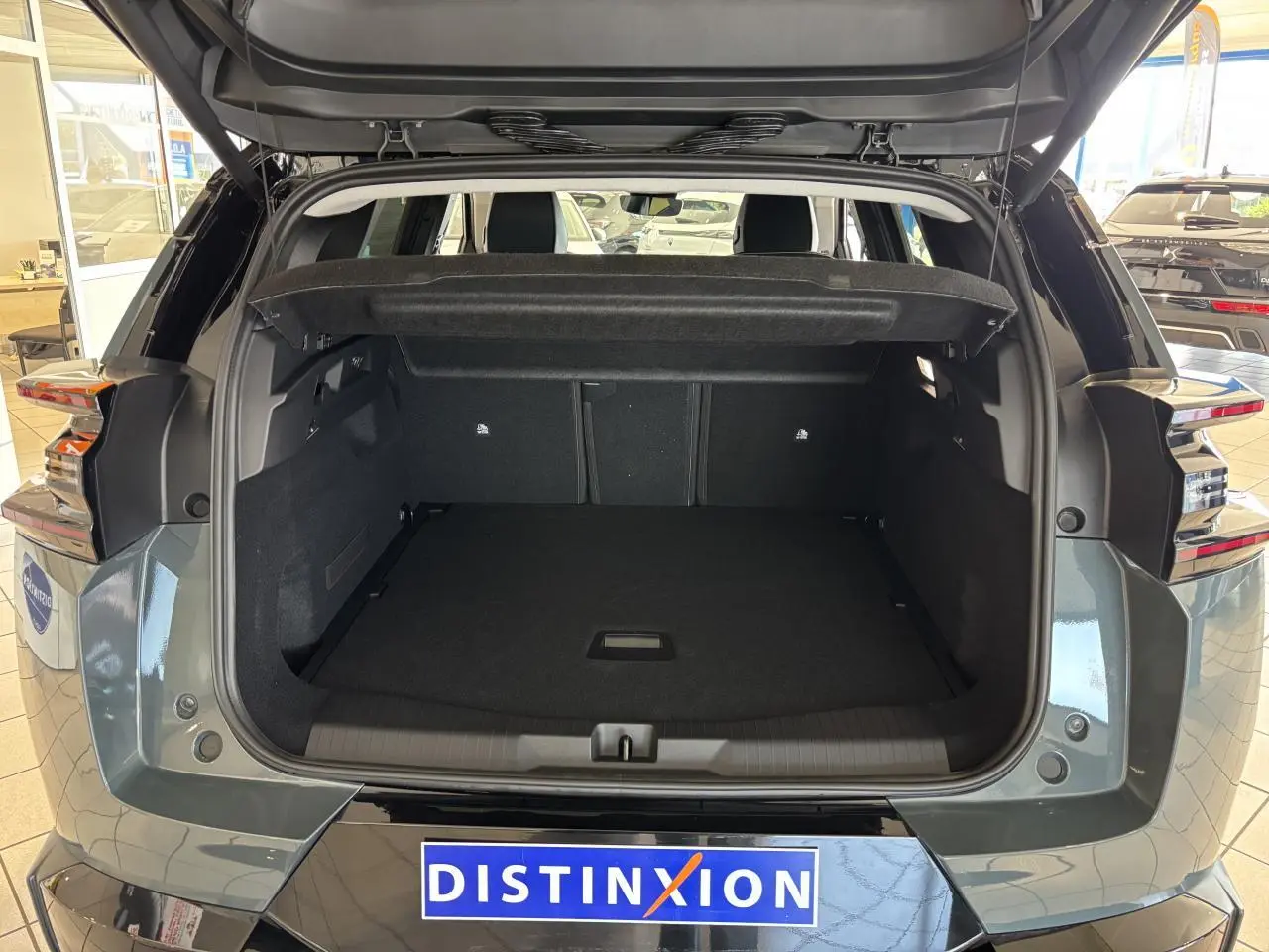 Coffre ouvert vu de l'arrière d'un Citroën C5 Aircross 2026 vert métallisé avec feux arrière LED distinctifs.