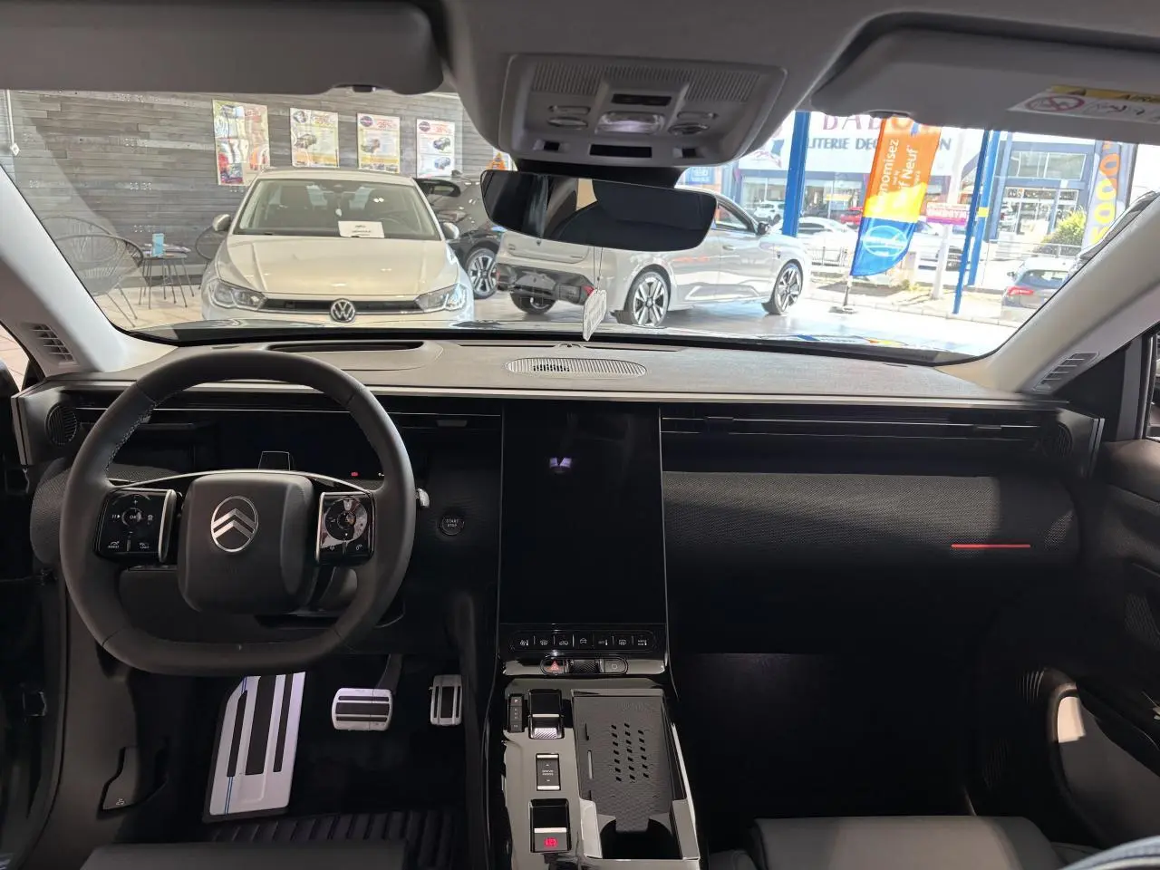 Vue intérieure avant du Citroën C5 Aircross 2026, tableau de bord noir avec écran tactile vertical et volant multifonctions.
