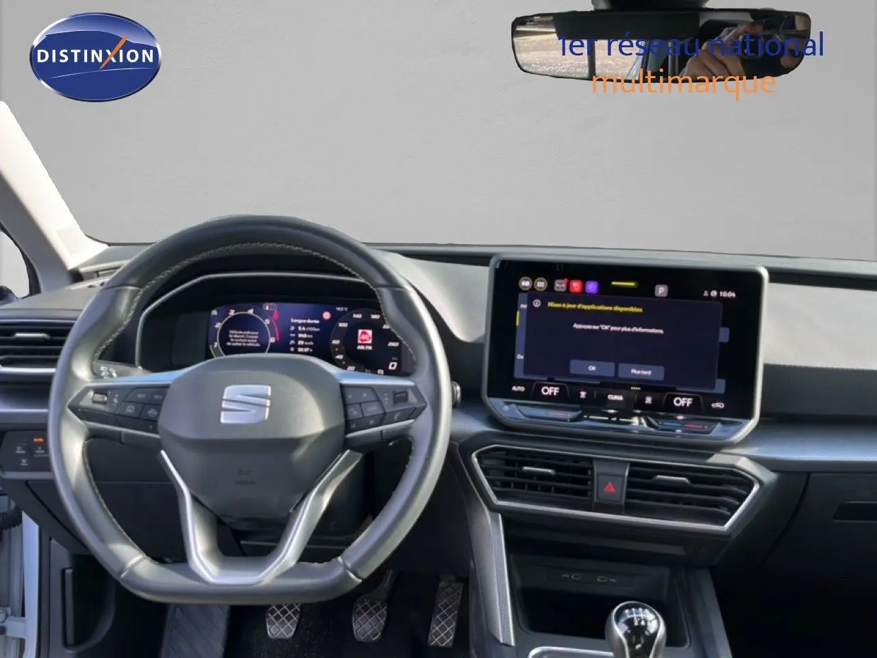 Vue intérieure du tableau de bord du SEAT LEON 2025 blanc neige, avec volant multifonction et écran tactile central.