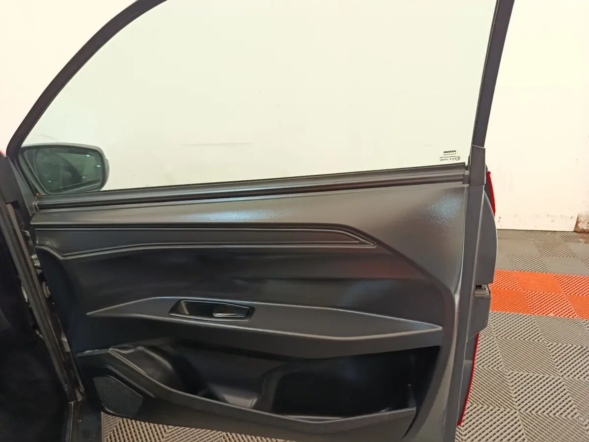 Vue rapprochée de la porte côté conducteur ouverte d’une AIXAM AMBITION 0.5 CITY PACK rouge 2024.