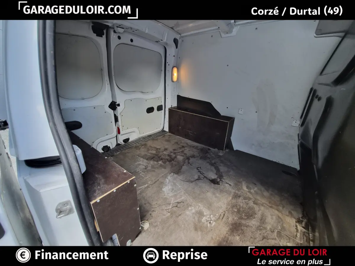 Vue intérieure du coffre arrière blanc du Renault Kangoo Extra R-Link dCi 90 avec plancher usé et parois claires.