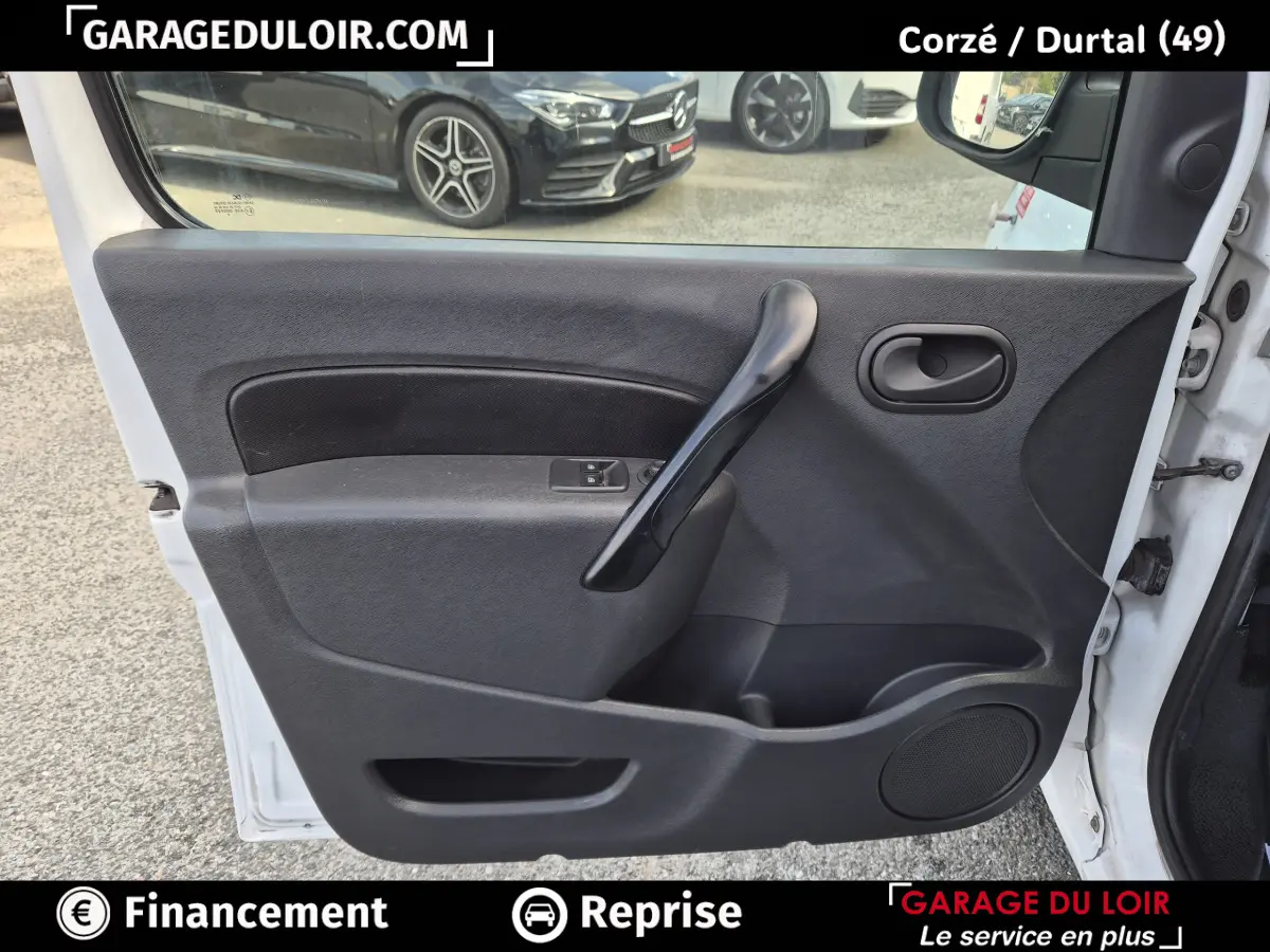 Vue intérieure côté gauche de la porte avant noire du Renault Kangoo Extra R-Link dCi 90 blanche, avec poignée et commande de vitre.