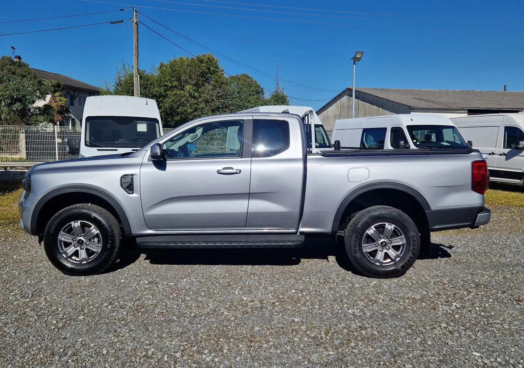 Vue de profil côté gauche du Ford Ranger Super Cabine gris iconic 2026 avec benne et jantes alliage 17 pouces.