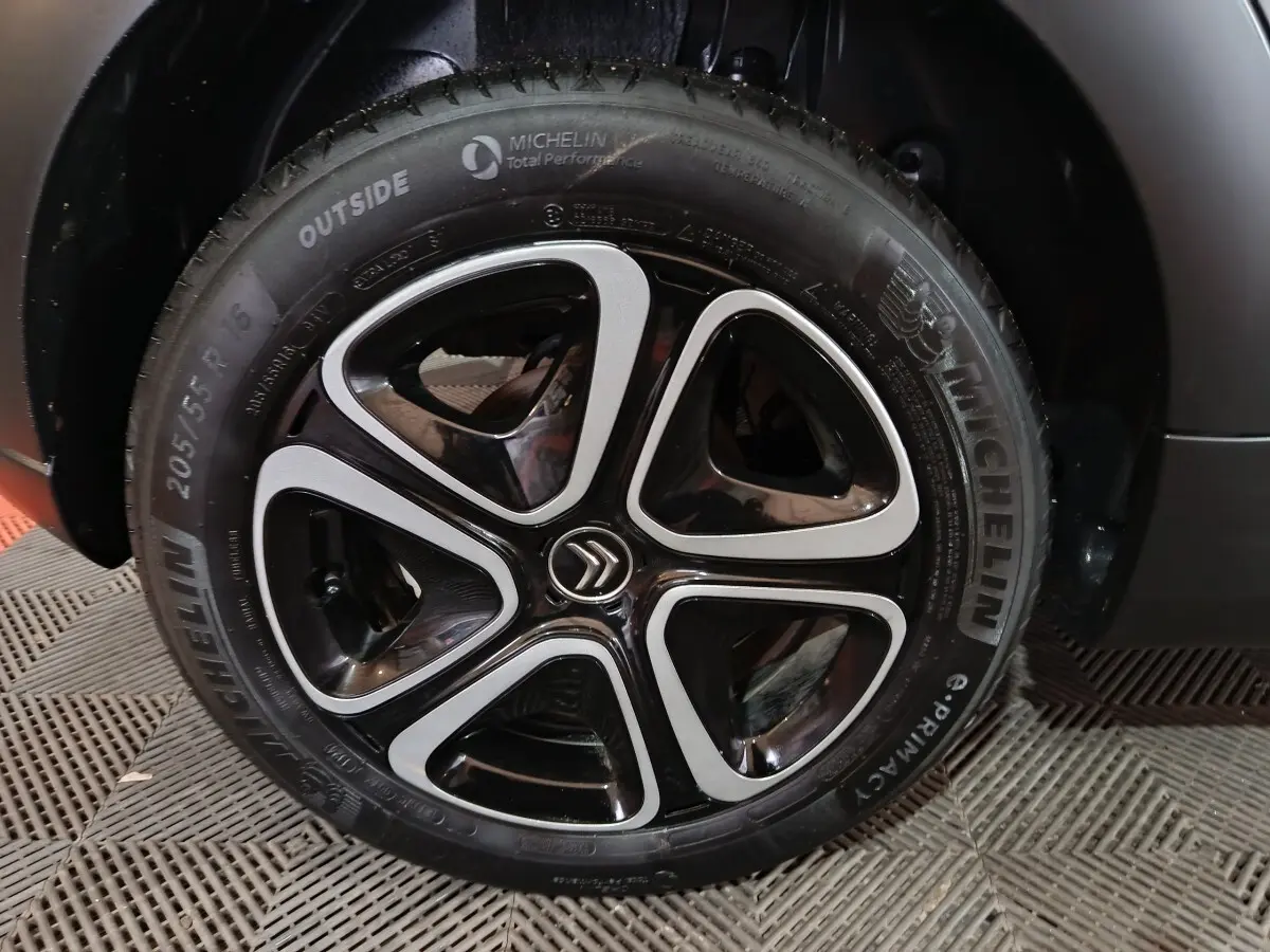 Gros plan sur la roue avant droite gris clair de la Citroën C3 2024 avec jante alliage noire et argentée au logo Citroën.