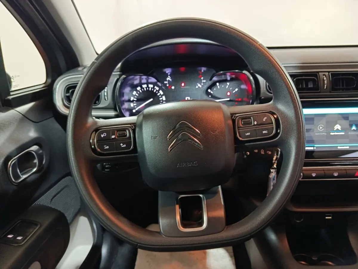 Vue intérieure centrée sur le volant noir multifonctions et le tableau de bord digital de la Citroën C3 2024.