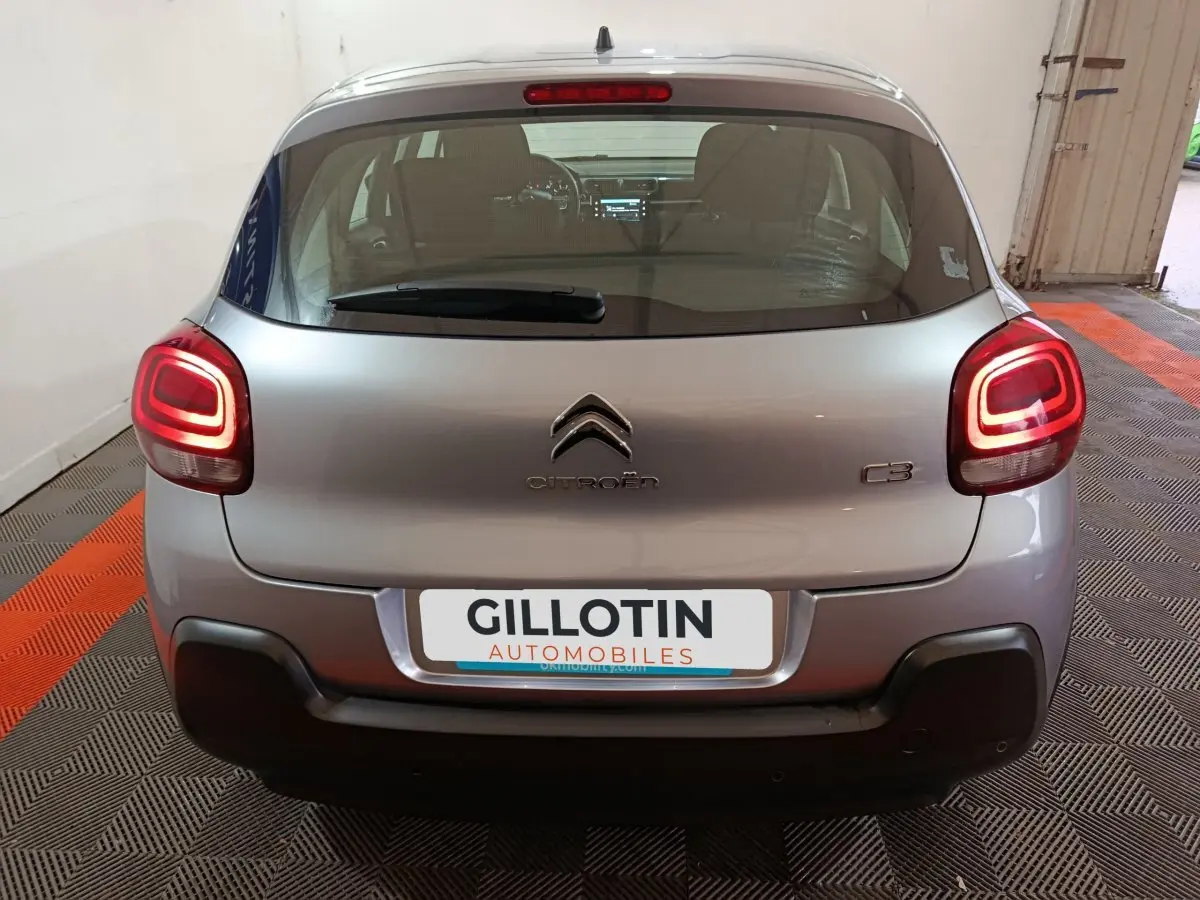 Vue arrière d'une Citroën C3 gris clair 2024 avec feux LED allumés et pare-chocs noir contrastant.