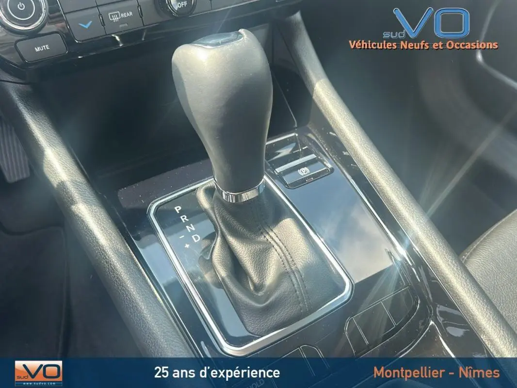 Le levier de vitesse automatique en cuir noir du Jeep Compass 2024, avec indication P R N D et frein à main électronique.