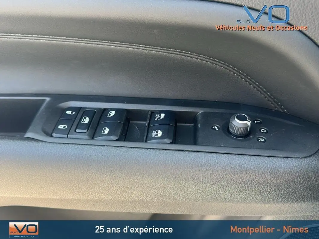 Gros plan sur la commande des vitres et rétroviseurs côté conducteur du Jeep Compass blanc 2024 avec pack hiver.