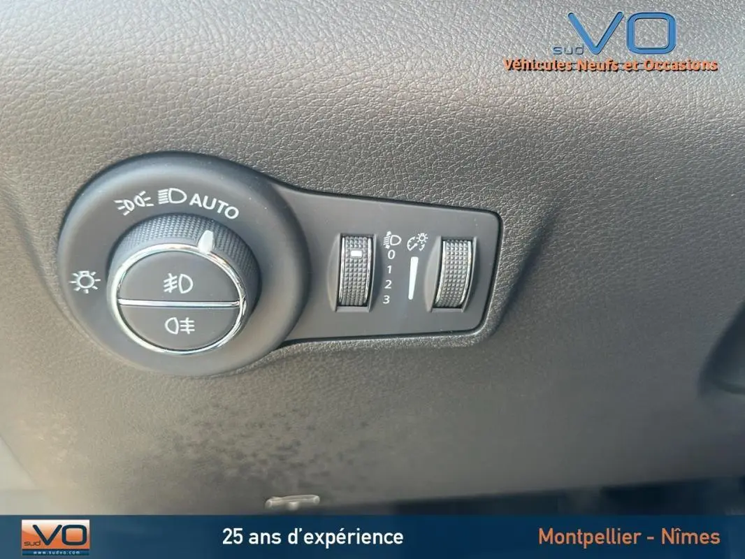 Commande des phares avec réglages de luminosité sur le tableau de bord noir du Jeep Compass blanc 2024 e-Hybrid Altitude