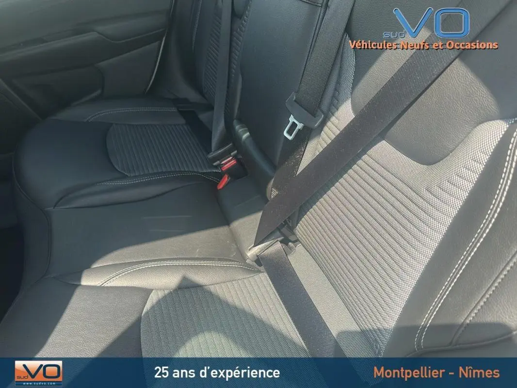 Gros plan sur la banquette arrière en cuir noir du Jeep Compass 2024, avec ceinture de sécurité attachée.