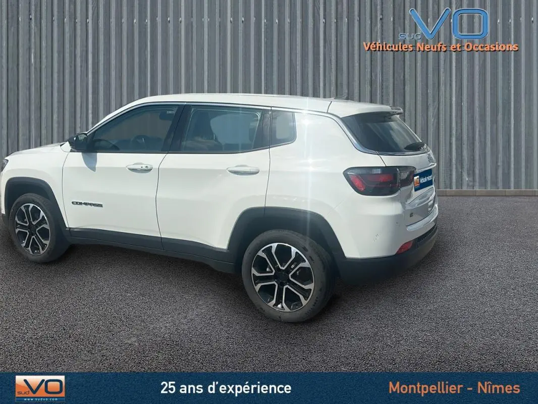 Vue latérale côté gauche d'un Jeep Compass blanc 2024 avec jantes 17 pouces et roue de secours visible à l'arrière.
